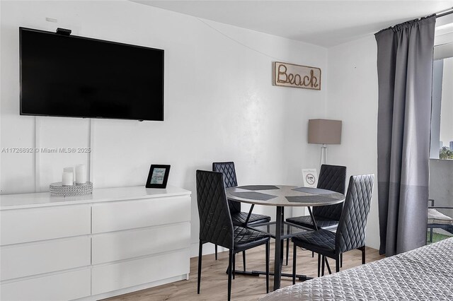 bedroom featuring white fridge and light hardwood / wood-style floors