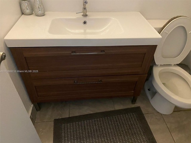 bathroom featuring toilet, tile patterned floors, and vanity