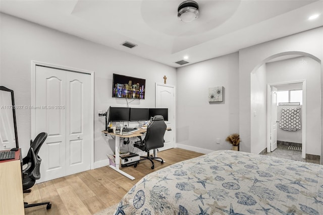 bedroom featuring ceiling fan, a raised ceiling, and hardwood / wood-style floors