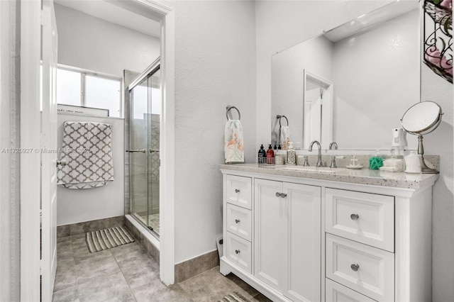 bathroom with tile patterned flooring, a shower with shower door, and vanity