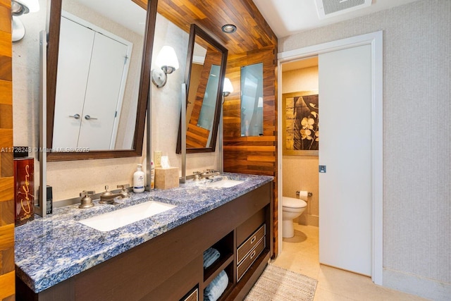 bathroom with toilet, vanity, and tile patterned floors