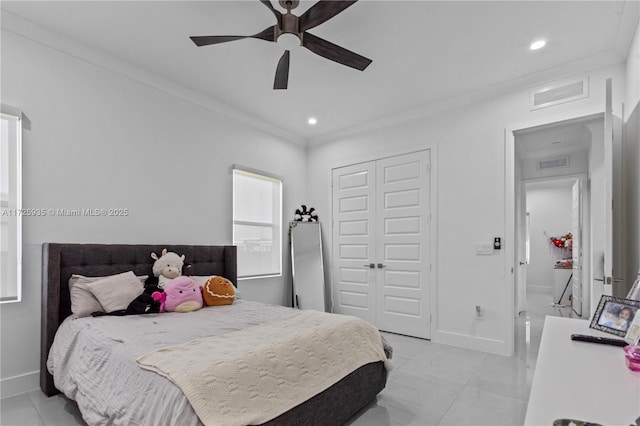 tiled bedroom featuring ceiling fan, a closet, and ornamental molding