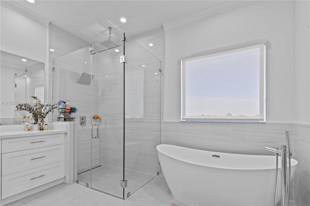 bathroom with tile walls, separate shower and tub, and vanity