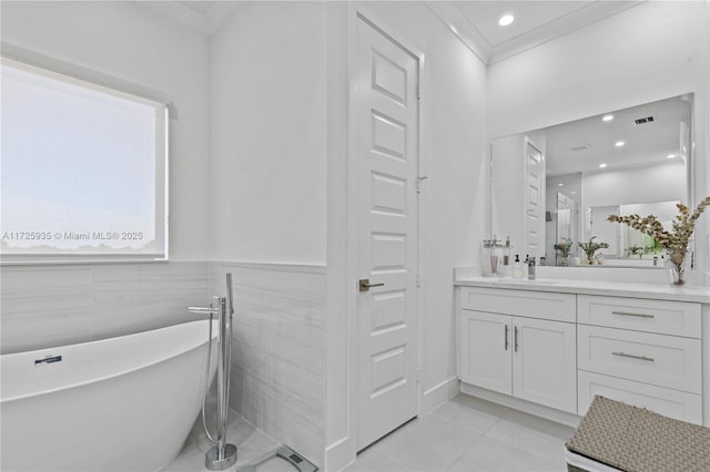 bathroom featuring tile patterned flooring, vanity, tile walls, a bath, and crown molding