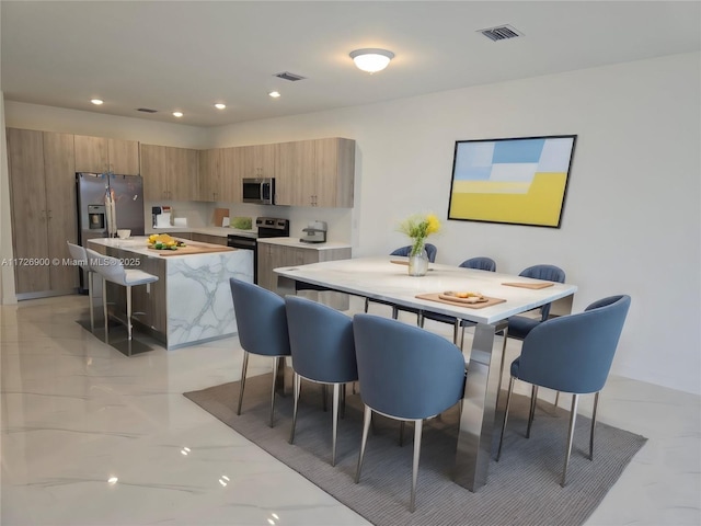 kitchen with stainless steel appliances, a kitchen bar, and a center island