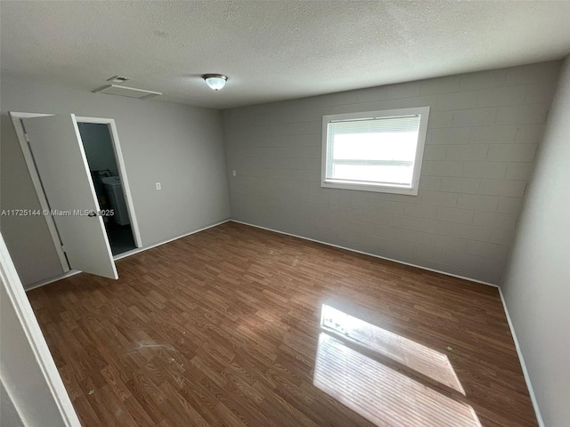 empty room featuring a textured ceiling and dark hardwood / wood-style flooring