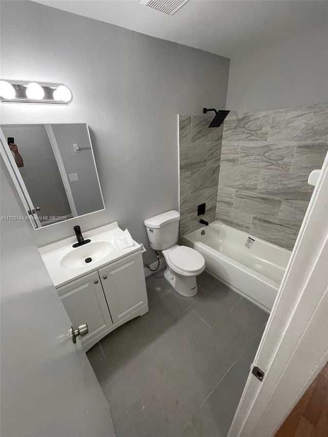 full bathroom featuring toilet, tile patterned floors, vanity, and tiled shower / bath