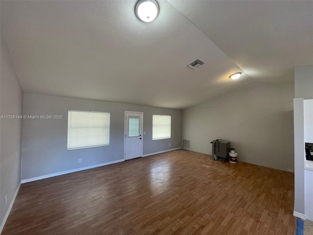 unfurnished living room featuring dark hardwood / wood-style floors and lofted ceiling