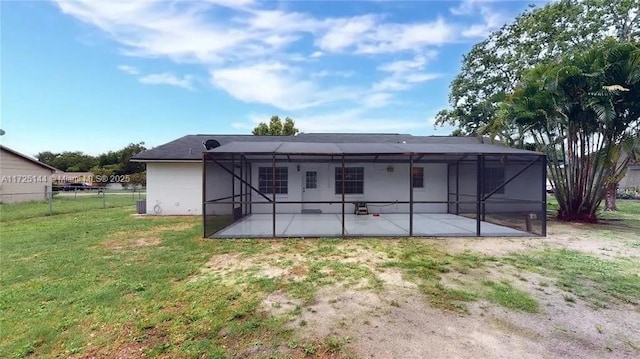 back of house featuring glass enclosure, central air condition unit, a patio area, and a lawn