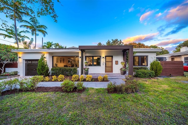 view of front of house with a garage and a lawn