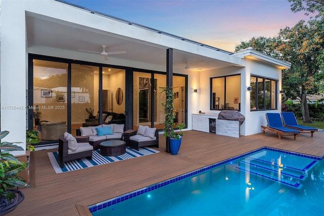 back house at dusk featuring an outdoor living space, a pool side deck, and ceiling fan