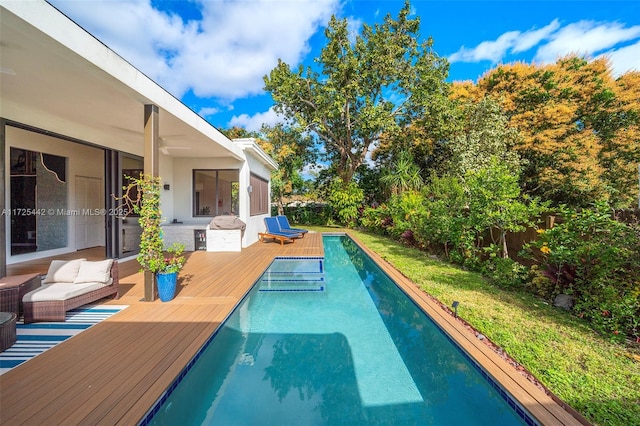 view of pool featuring a yard, outdoor lounge area, and a wooden deck