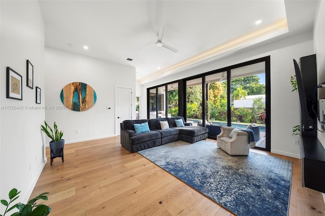 living room featuring light wood-type flooring, ceiling fan, and french doors