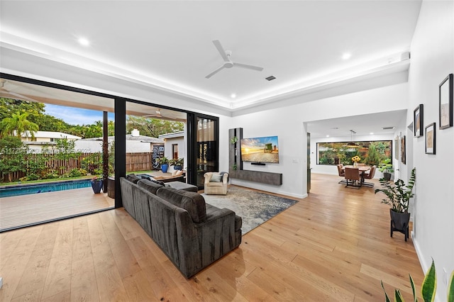 living room with ceiling fan and light hardwood / wood-style floors