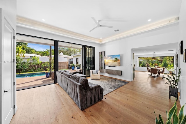 living room with ceiling fan and light hardwood / wood-style flooring