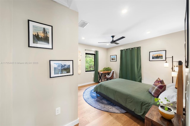 bedroom with ceiling fan and hardwood / wood-style flooring