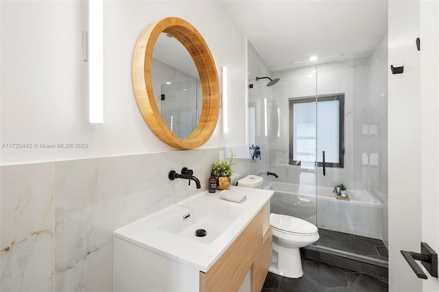 bathroom featuring toilet, vanity, tile walls, tile patterned flooring, and an enclosed shower