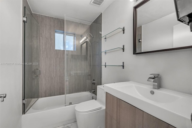 full bathroom with shower / bath combination with glass door, vanity, and toilet