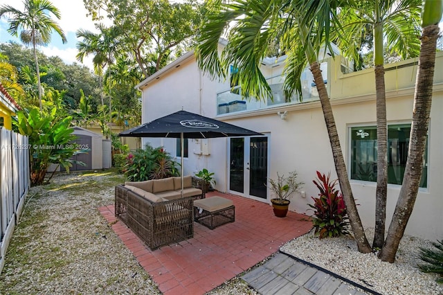 view of patio with outdoor lounge area, french doors, and a shed