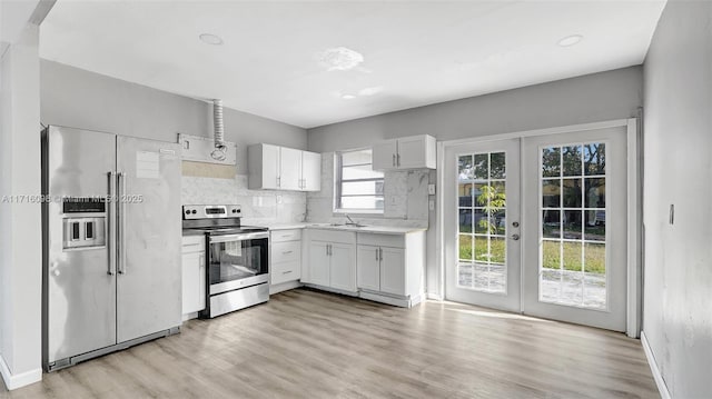 kitchen with backsplash, white cabinetry, appliances with stainless steel finishes, and french doors