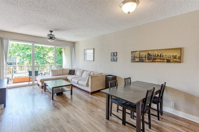 living room featuring ceiling fan, wood-type flooring, and a textured ceiling