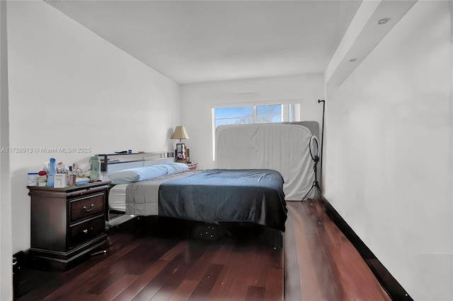 bedroom with dark hardwood / wood-style flooring