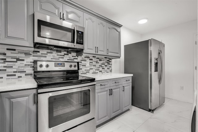 kitchen with decorative backsplash, gray cabinets, and stainless steel appliances