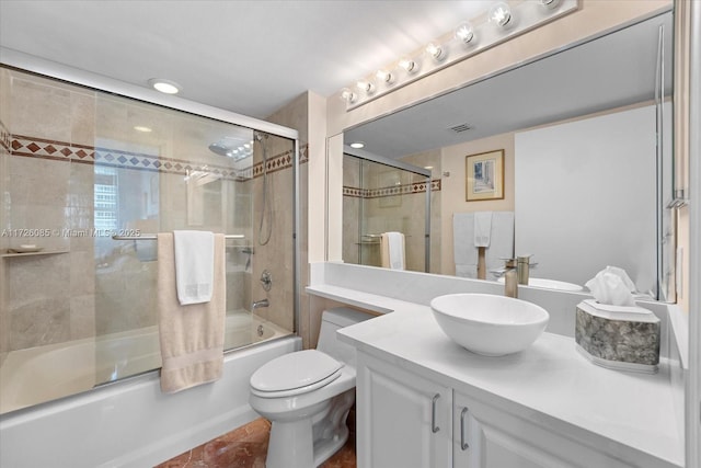 full bathroom featuring combined bath / shower with glass door, vanity, and toilet