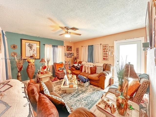 living room with ceiling fan and a textured ceiling