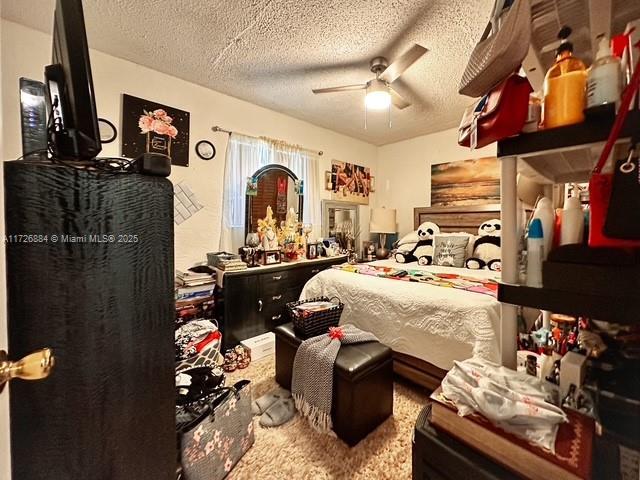 bedroom featuring ceiling fan and a textured ceiling