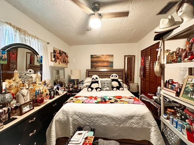 bedroom featuring ceiling fan and a textured ceiling