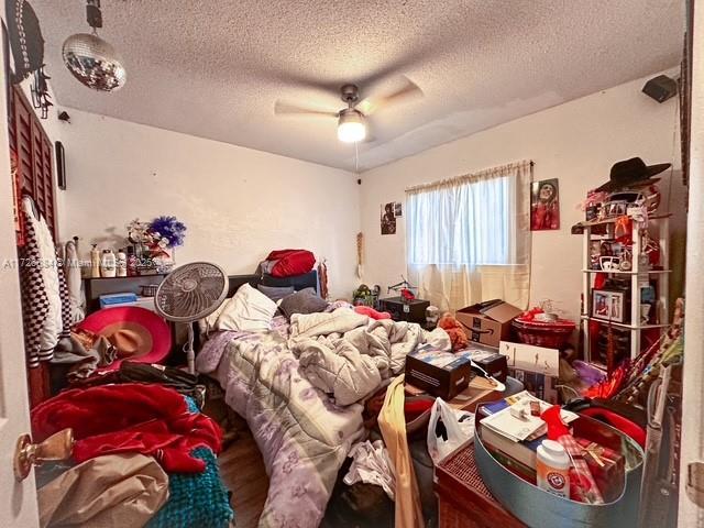 bedroom featuring ceiling fan, a textured ceiling, and hardwood / wood-style flooring