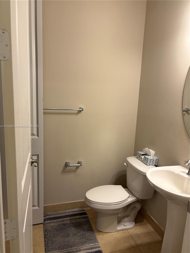 bathroom with toilet and tile patterned floors