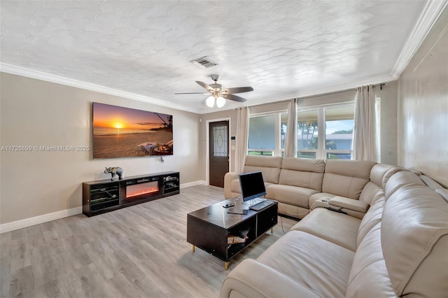 living room with ceiling fan, a textured ceiling, ornamental molding, and hardwood / wood-style flooring