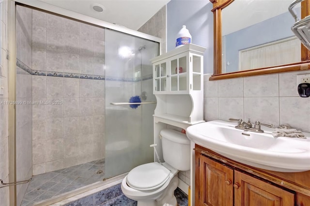 bathroom with backsplash, toilet, vanity, and an enclosed shower