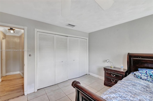 bedroom featuring a closet, ornamental molding, and light tile patterned flooring