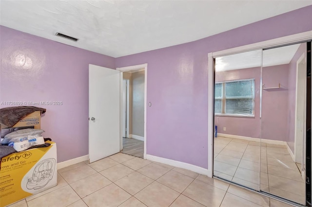 unfurnished bedroom with light tile patterned floors and a closet