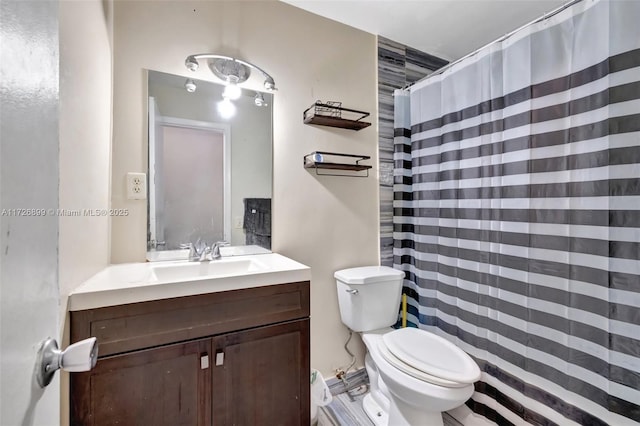 bathroom featuring toilet, vanity, and walk in shower