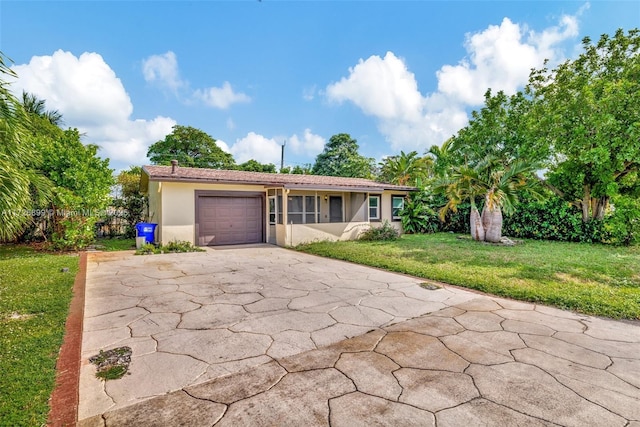 ranch-style home with a garage and a front lawn