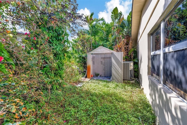 view of yard featuring a storage shed and central AC