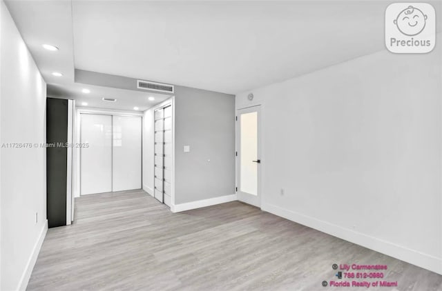 empty room with light hardwood / wood-style flooring