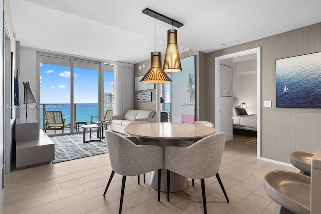 dining area with a water view and expansive windows