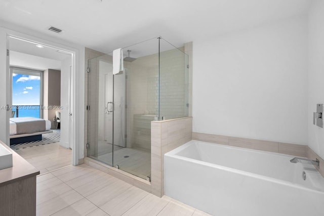 bathroom featuring tile patterned floors, separate shower and tub, and vanity