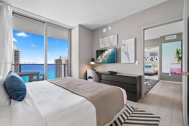 bedroom featuring expansive windows and access to outside