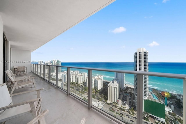 balcony featuring a view of the beach and a water view