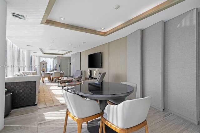 tiled dining area with a tray ceiling