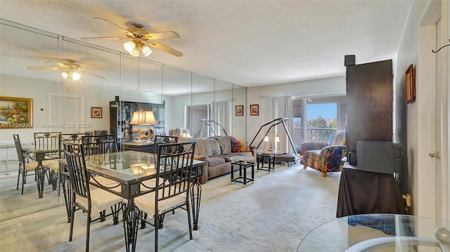 dining area with ceiling fan, a textured ceiling, and light carpet