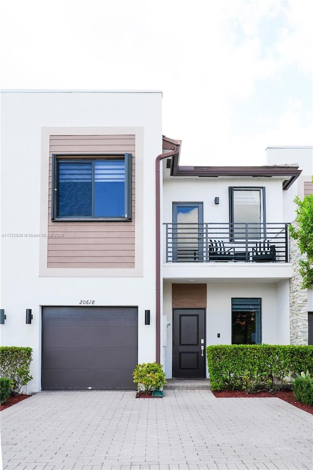 contemporary house featuring a garage and a balcony