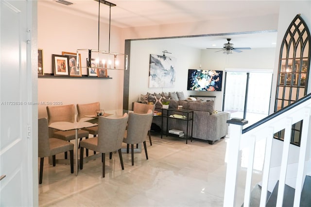 dining room featuring ceiling fan with notable chandelier