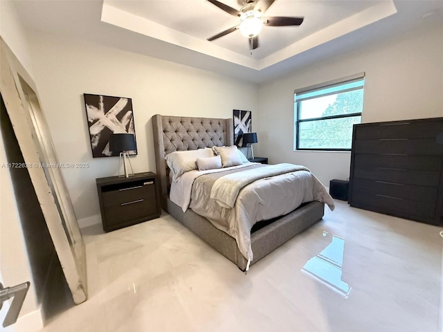 bedroom with ceiling fan and a tray ceiling